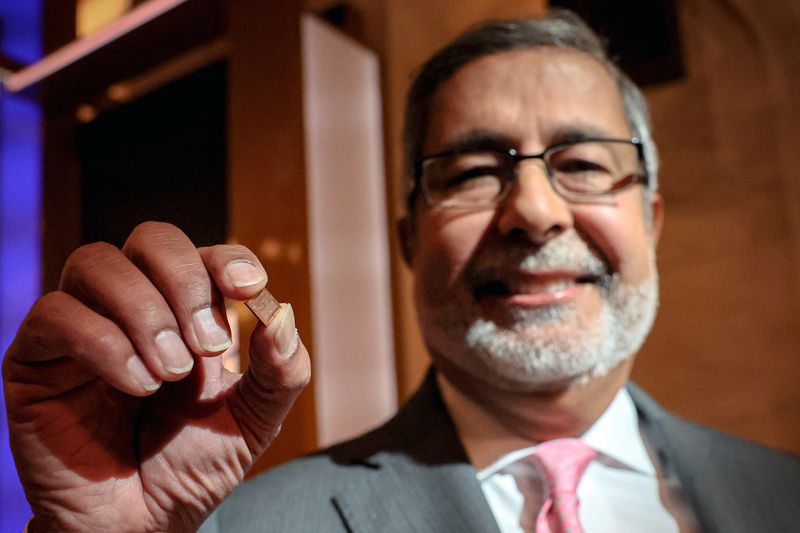 © Reuters. FILE PHOTO: Sanjay Mehrotra, CEO of Micron Technology Inc., shows a  chip on the floor at the New York Stock Exchange (NYSE) in New York City, U.S., April 26, 2024.  REUTERS/Brendan McDermid/File Photo