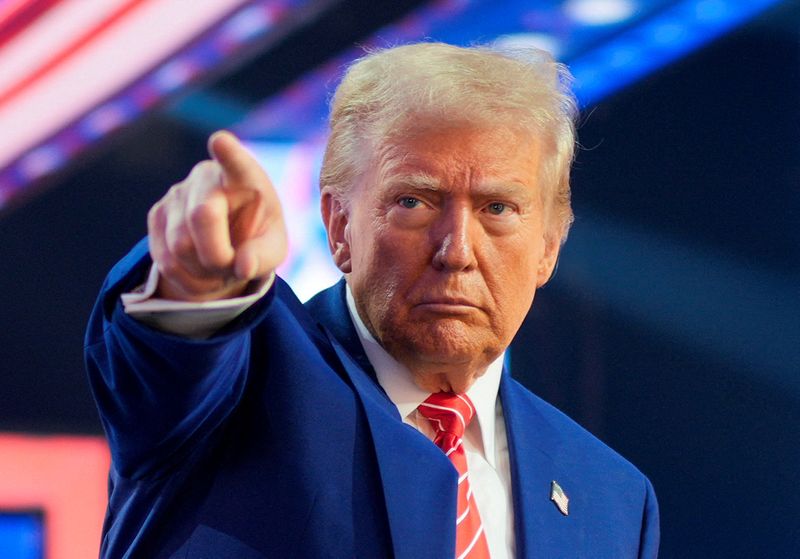 © Reuters. FILE PHOTO: U.S. President-elect Donald Trump gestures at Turning Point USA's AmericaFest in Phoenix, Arizona, U.S., December 22, 2024.  REUTERS/Cheney Orr/File Photo