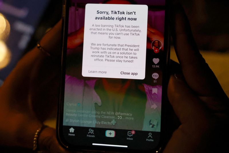 © Reuters. A woman poses with her smartphone displaying the TikTok app, after it stopped working in the United States late on Saturday and disappeared from Apple and Google app stores ahead of a law that takes effect Sunday requiring the shutdown of the app used by 170 million Americans, in Washington, U.S. January 18, 2025. REUTERS/Shannon Stapleton